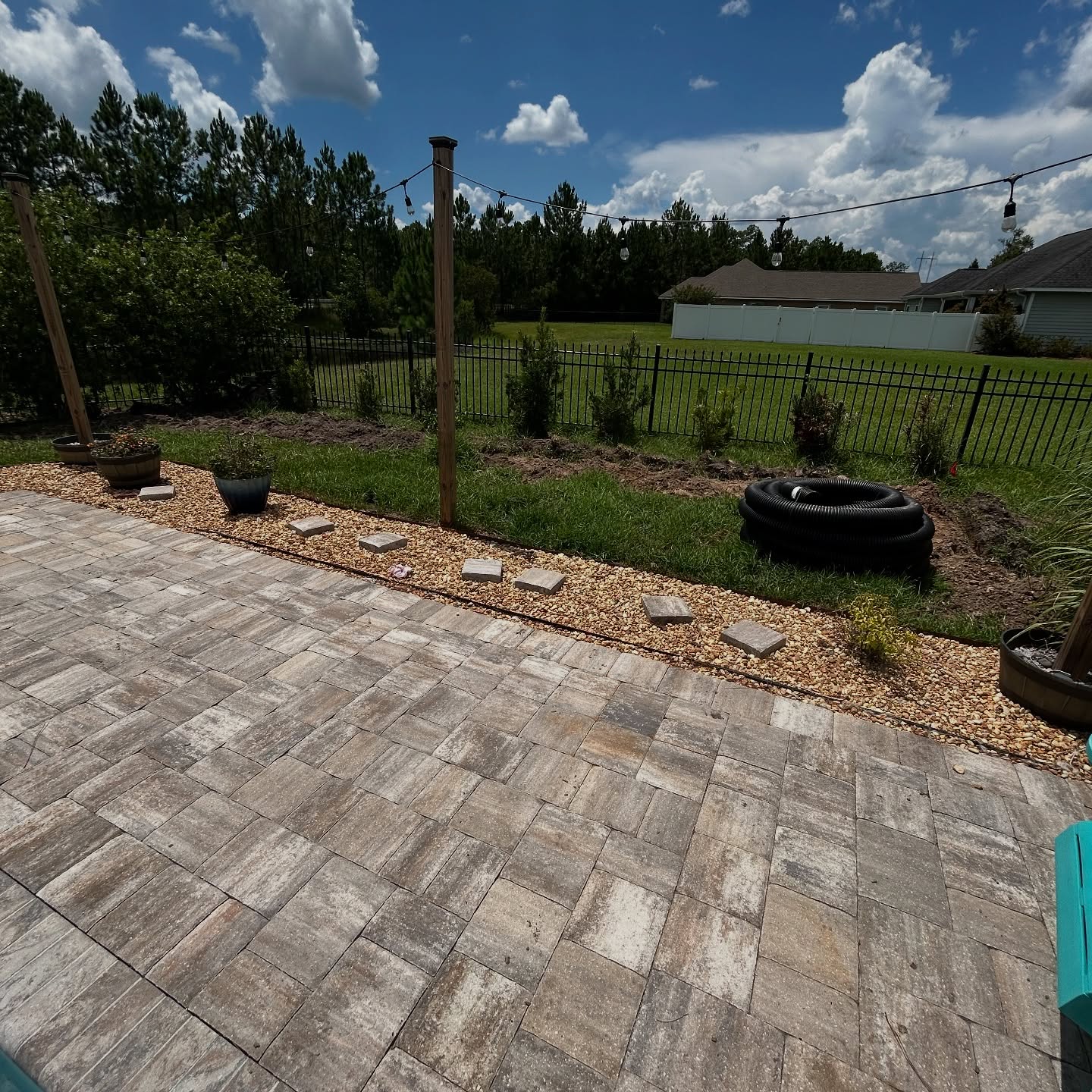 Finished backyard patio edge with drainage pipe